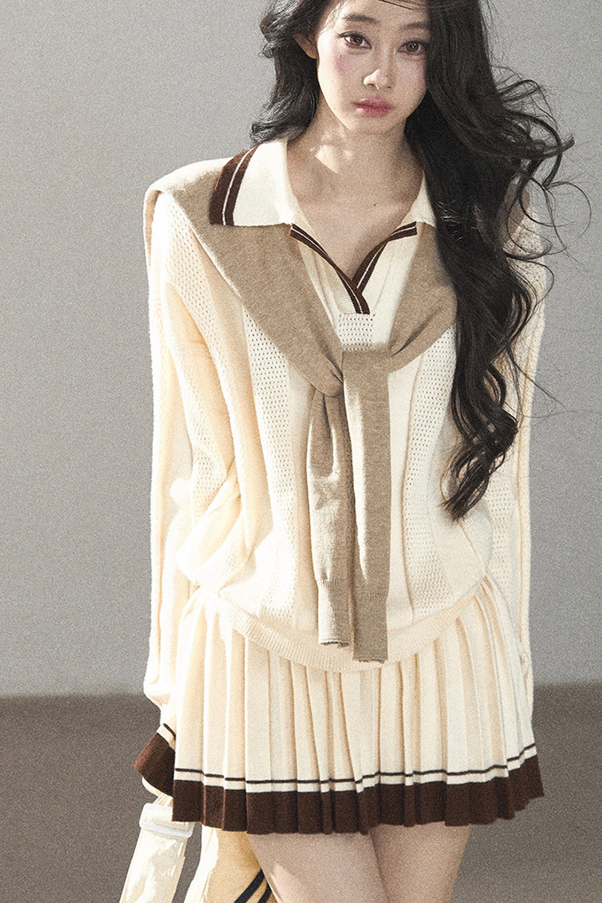 Completo con top a maglia, gonna corta plissettata e giacca