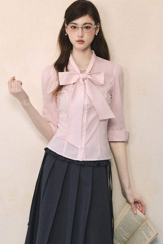Camisa rosa de manga larga con lazada al cuello y mariposa