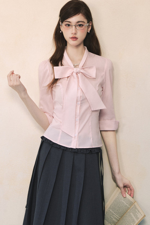 Camisa rosa de manga larga con lazada al cuello y mariposa
